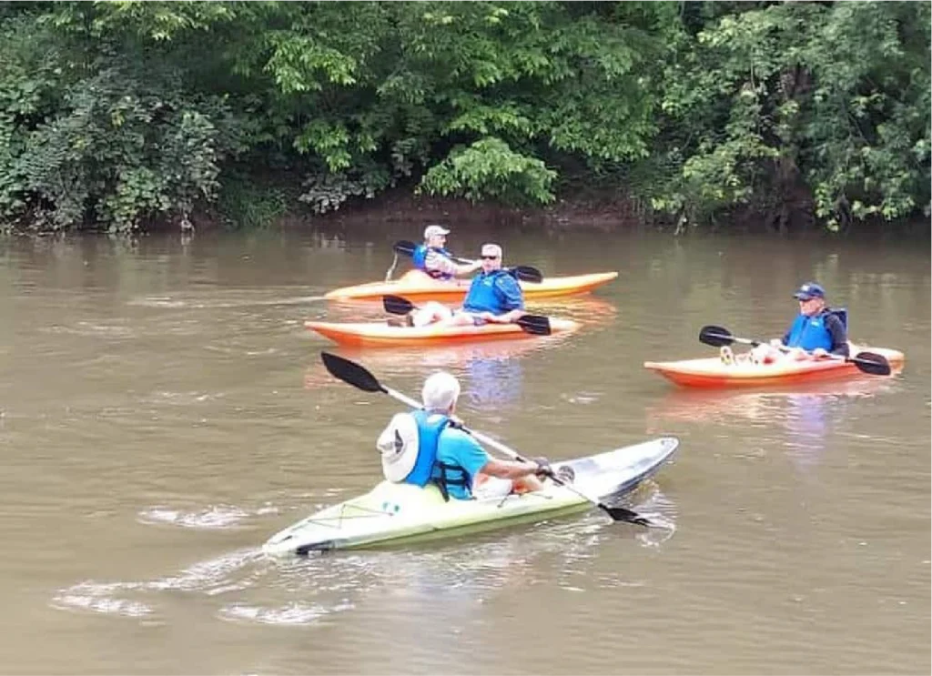 Kayakers paddling along the Little Miami River during a relaxing self-guided river trip.